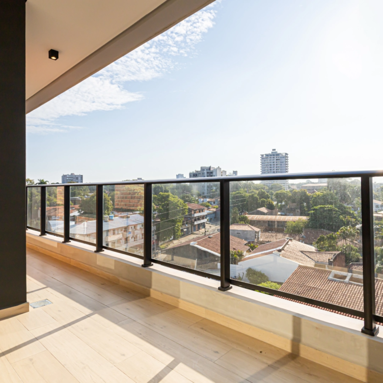 Balcon avec garde-corps vitré et vue dégagée sur le quartier, dans l’immeuble Imagina Ycua Satí à Asunción, Paraguay.