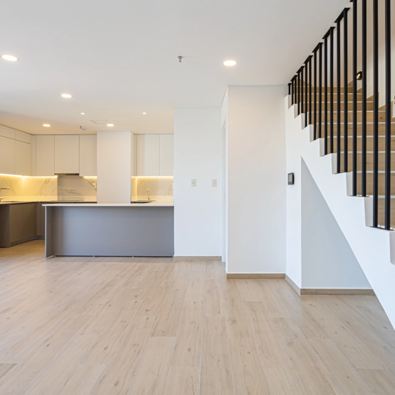 Cuisine ouverte avec îlot et escalier d’un duplex non meublé dans l’immeuble Imagina Ycua Satí à Asunción, Paraguay.