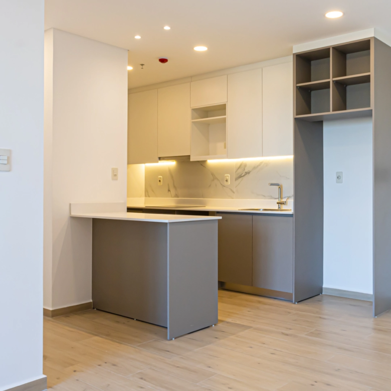 Cuisine équipée avec plan de travail clair et rangements dans un appartement de l’immeuble Imagina Ycua Satí à Asunción, Paraguay.