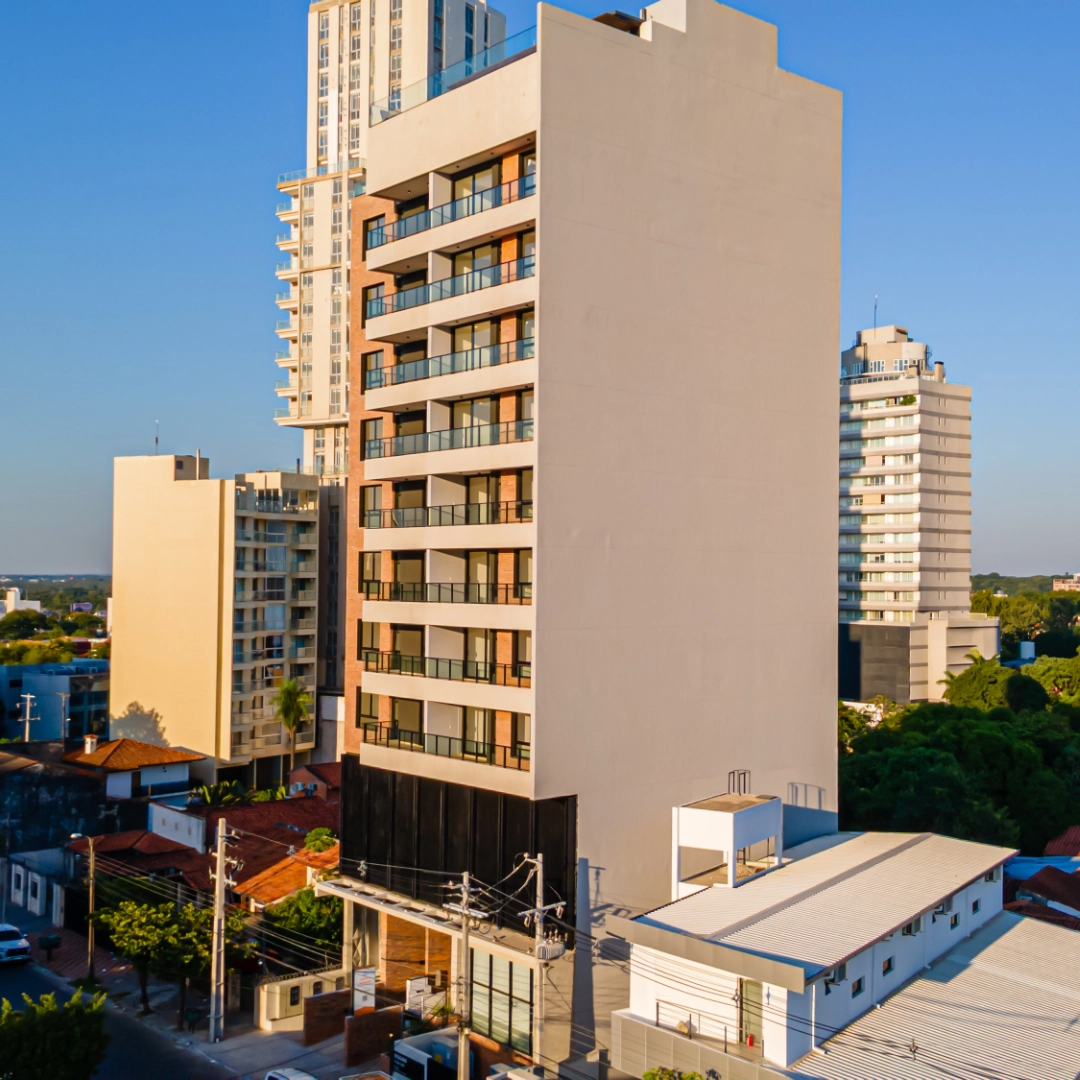 Façade aux balcons vitrés de l’immeuble Imagina Ycua Satí dans la lumière du soir, à Asunción, Paraguay.
