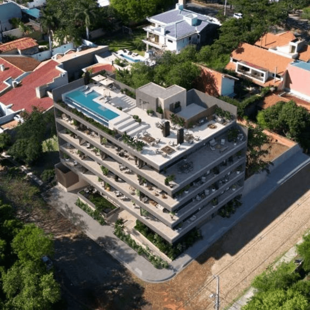 Immeuble résidentiel moderne avec rooftop, piscine et grandes terrasses dans un quartier arboré d’Asunción, au Paraguay.