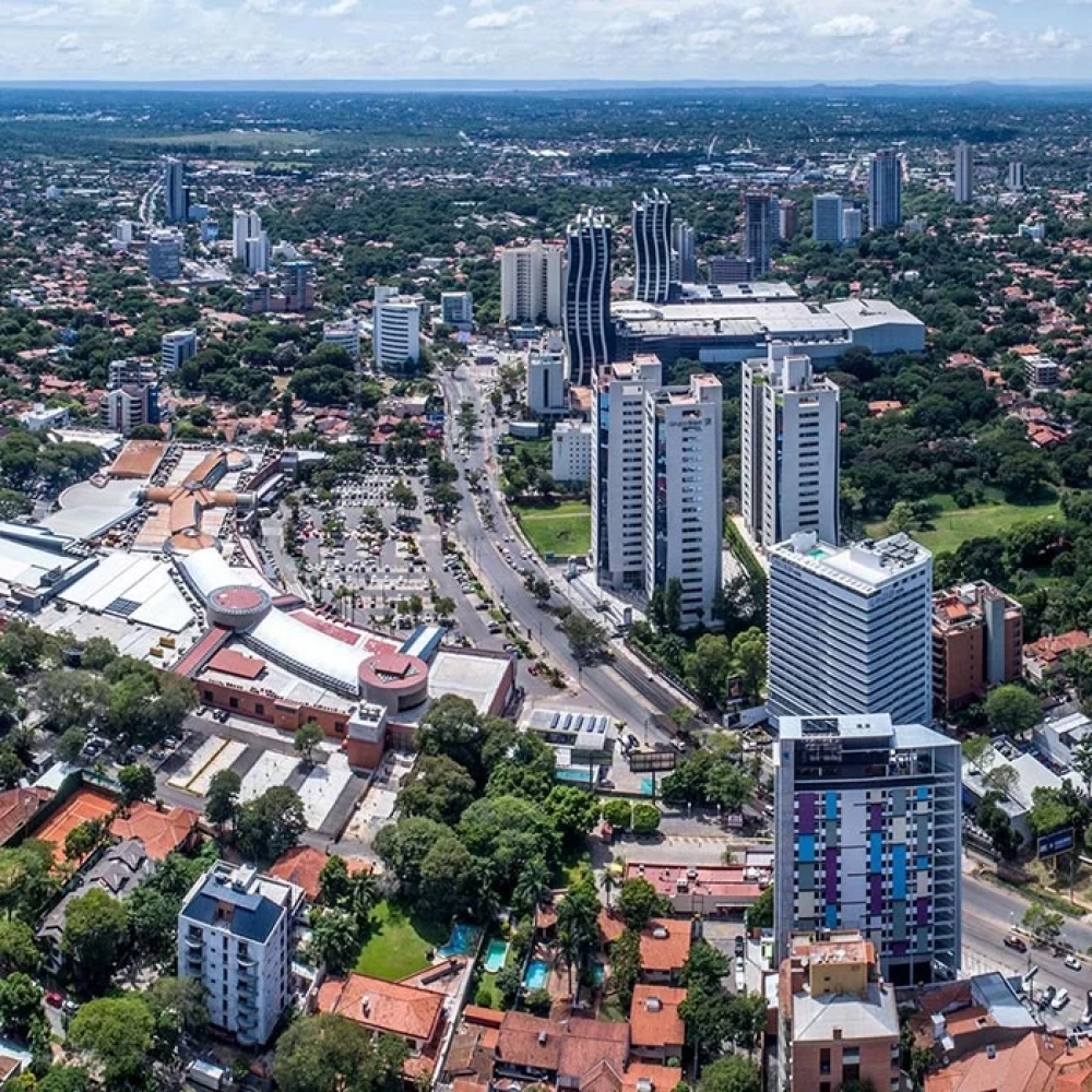 Panorama aérien du quartier d’affaires d’Asunción au Paraguay, avec ses tours résidentielles et commerciales, ses grands axes routiers et ses nombreux espaces verts.