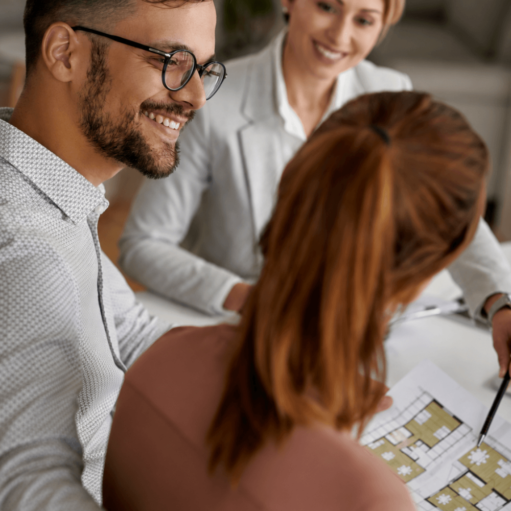 Investisseurs étudiant le plan d’un projet immobilier avec une conseillère au Paraguay